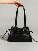 Reco L'erreur black Napa leather drawstring bucket bag with gold hardware and adjustable straps.