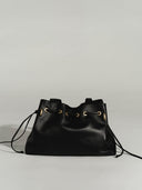 Reco L'erreur black leather drawstring bucket bag with gold hardware and adjustable straps.