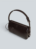 Reco Casa compact rosewood leather baguette bag with adjustable strap and signature key charm.
