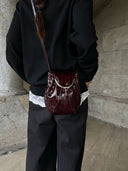 Reco Clam Shell crossbody bag in deep red coral patent leather with kiss-lock clasp and natural pleats.