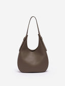 Reco Halston crescent shoulder bag in raw umber Togo calfskin with a natural pebbled texture and minimalist design.