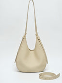 Reco Halston white Togo calfskin leather hobo bag with a minimalist curved silhouette and adjustable shoulder strap.