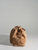 Reco L'erreur bucket bag in maple sugar nubuck leather with drawstring closure and adjustable straps.
