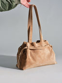 Reco L'erreur tote bag in maple sugar nubuck leather with drawstring closure and dual straps.