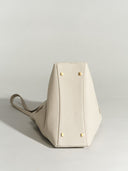 Reco L'erreur dumpling bag in Fog White pebbled Togo calfskin with gold-tone base studs, shown from the bottom view.