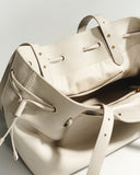 Reco L'erreur tote bag in Fog White Togo calfskin leather with drawstring closure and gold hardware.