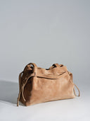 Reco L'erreur dumpling bag in maple sugar suede with a soft peach-skin texture and drawstring closure.