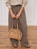 Reco. L'erreur dumpling bag in maple sugar suede with a soft peach-skin texture and drawstring closure.