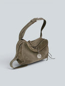 Reco Wander bag in algae suede with a compass charm and flying-tail zipper.