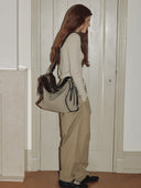 Reco Wander bag in acorn canvas with dark brown leather trim and zipper, worn by a model.