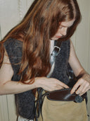 Reco. Wander bag in ebony sand suede and leather with a compass charm and flying-tail zipper.